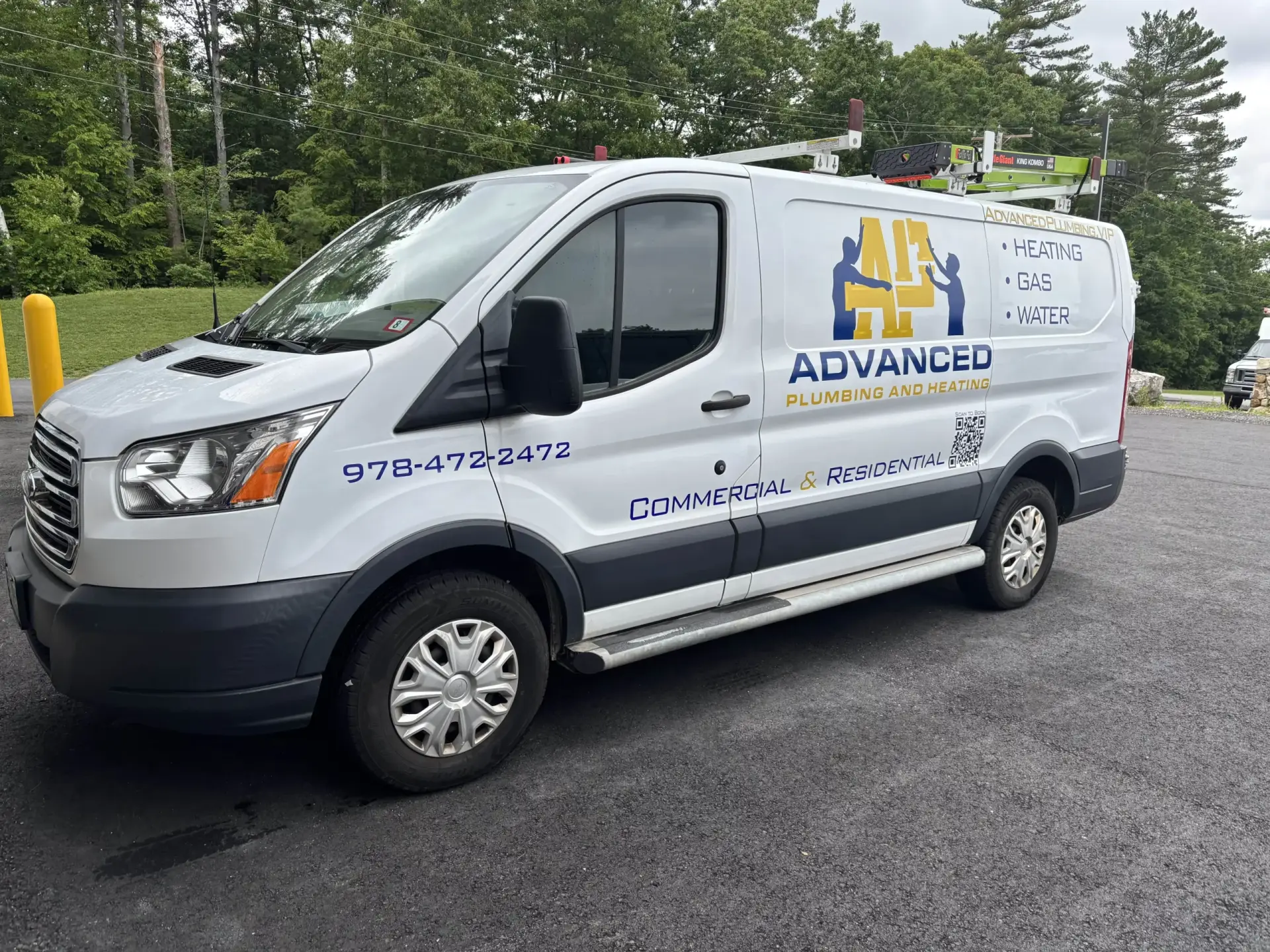 Advanced Plumbing and Heating service van with contact information and service offerings, parked in a green outdoor setting, showcasing vehicle graphics for branding.