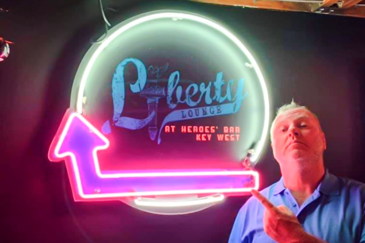 Neon sign for "Liberty Lounge" at Heroes' Bar in Key West with a pointing man, showcasing custom neon design by Signs East.