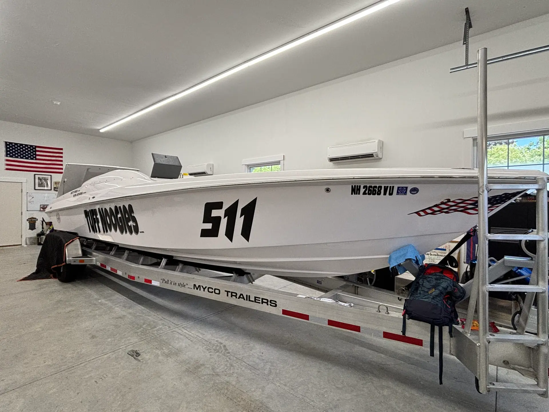 Boat on trailer in garage, featuring the name "Puff Noodles" and number "511," showcasing a clean, sleek design ideal for custom graphics and wraps.