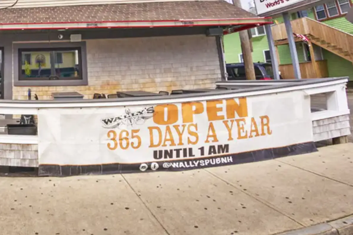 Vinyl banner for Wally's Pub advertising "OPEN 365 DAYS A YEAR UNTIL 1 AM" displayed on a storefront.