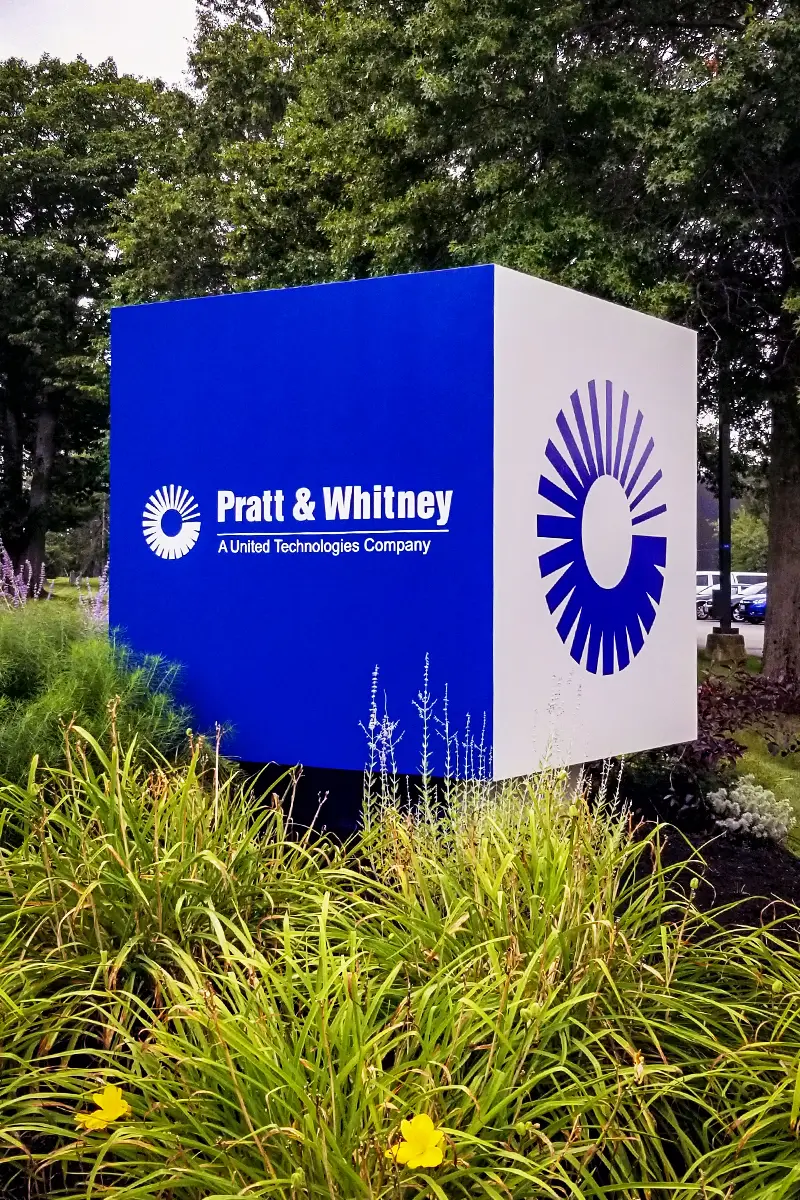 Pratt & Whitney corporate monument sign featuring blue and white design, surrounded by landscaping, representing commercial signage for professional offices.