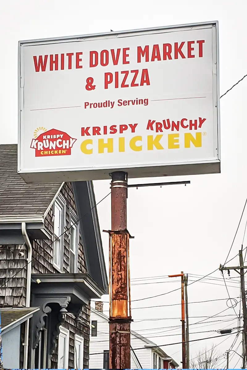 Freestanding pole sign for White Dove Market & Pizza featuring Krispy Krunchy Chicken, showcasing roadside visibility for local businesses.