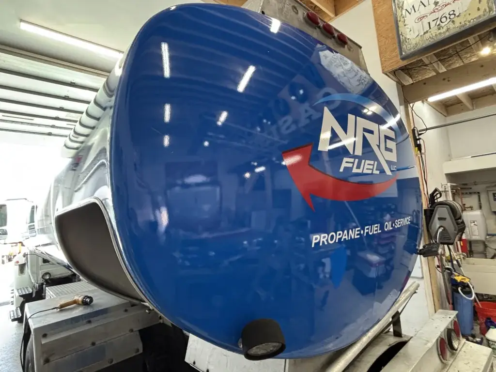 NRG Fuel propane tank with blue branding and service details, showcasing in-house sign fabrication quality and custom solutions for signage.