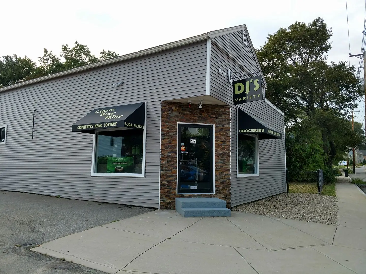 DJ's Variety storefront featuring awning signage for groceries, cigars, beer, and wine, with a focus on visibility and branding for local customers.